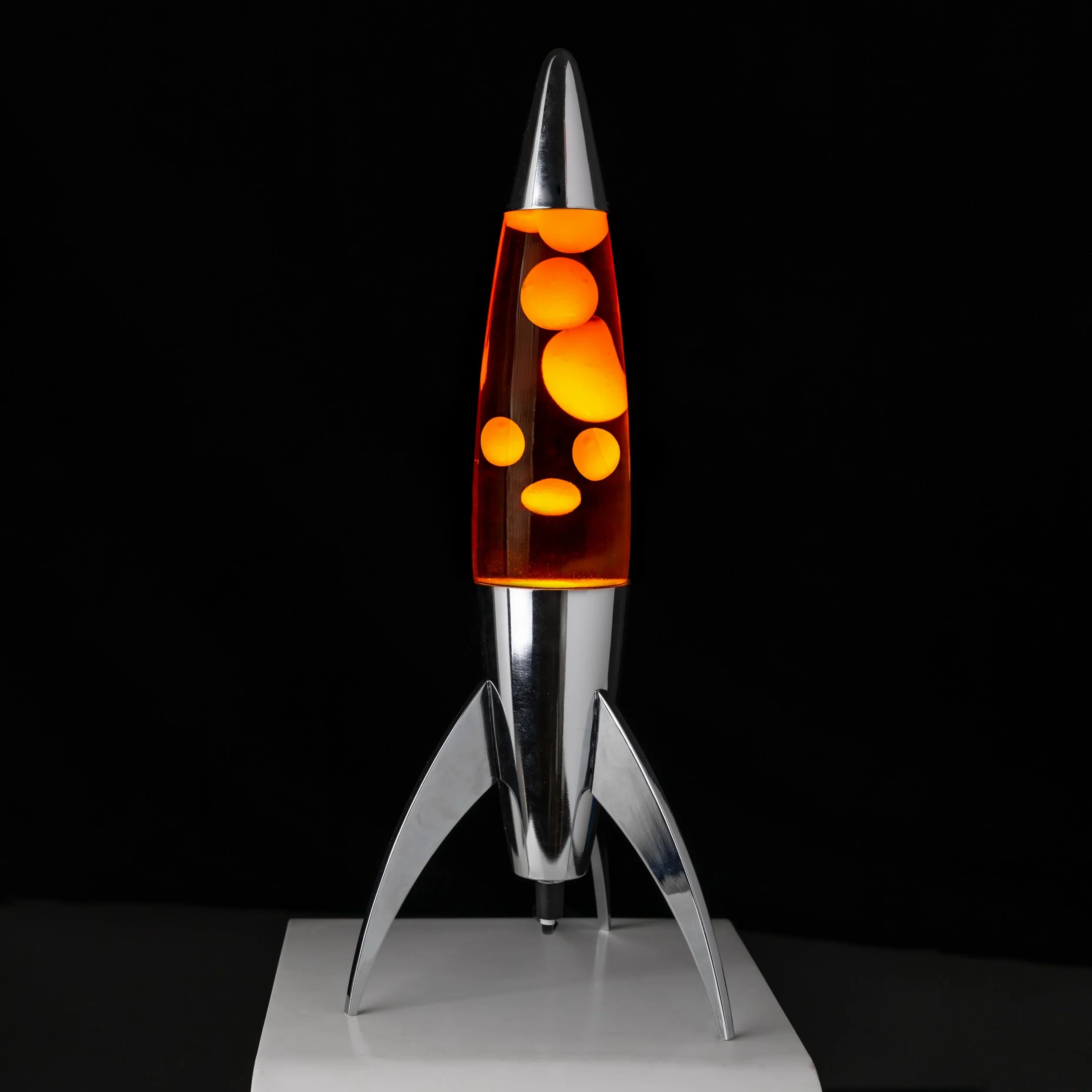 Fisura - Pomarańczowa lampa lawa "rocket”. Chromowana podstawa, pomarańczowy płyn i pomarańczowa lawa. Retro lampa magma z zapasową żarówką. 20 cm x 20 cm x 45 cm.